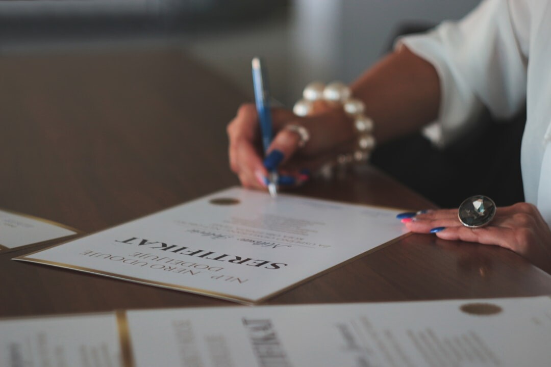 Close-up of hands reviewing and signing an inheritance legal document